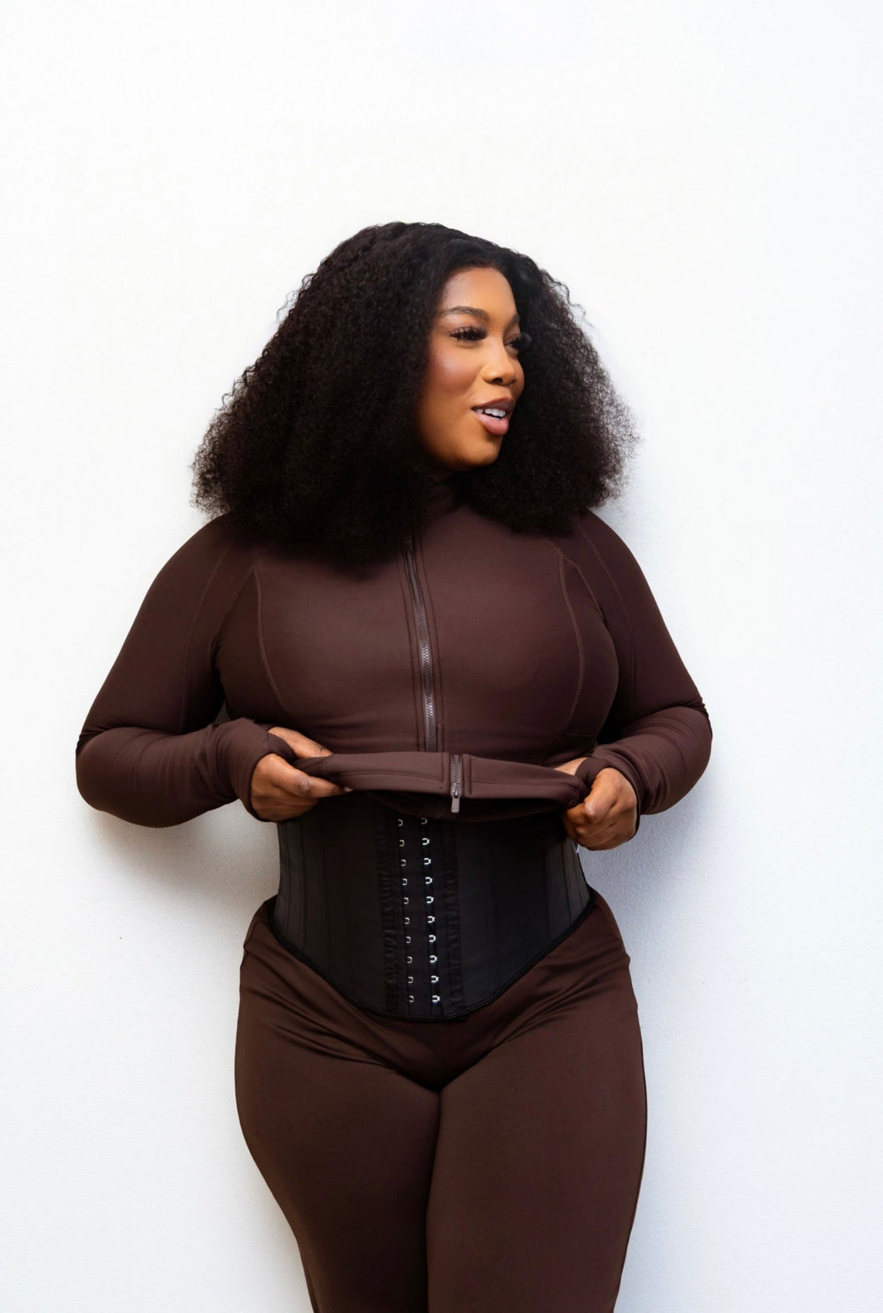 Steel bone waist trainer worn with brown sauna suit - smiling front view