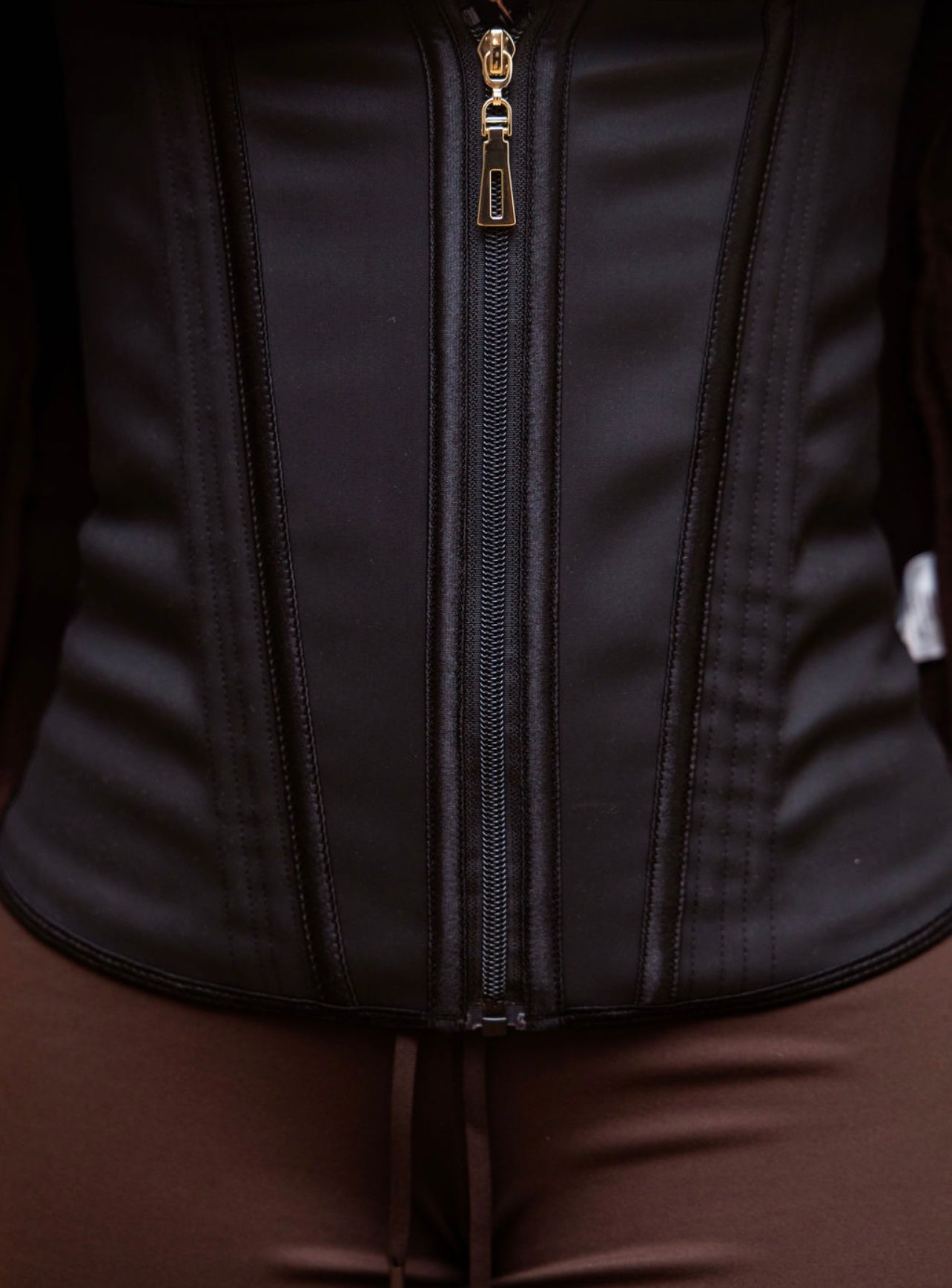 Detailed close-up of Steel Bone Waist Trainer zipper and boning panels in black